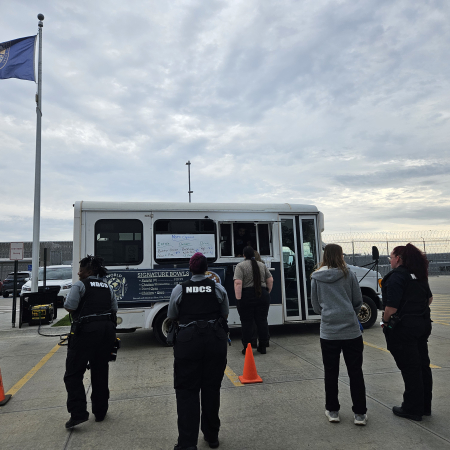 People waiting in line to order at a food truck in a parking lot